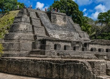 Altun Ha Maya ruins in Belize with ancient stone temple and visitors during a private Maya ruins tour.