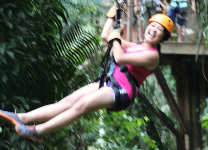 Guest ziplining on a private Xunantunich cave tubing adventure from Belize City