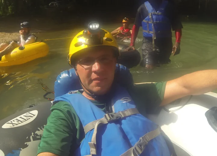 Guest floating through a Belize river cave on a Xunantunich tour from Placencia