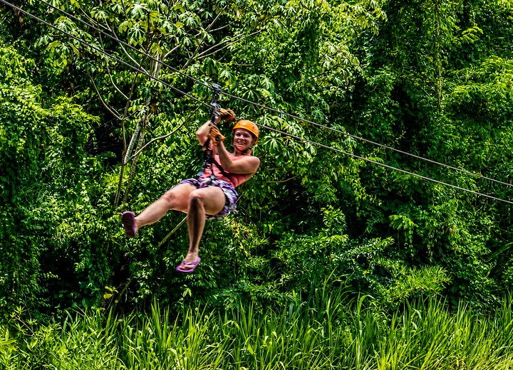 Guest ziplining through lush Belize rainforest on an adventure tour