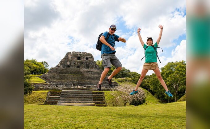 Travelers jumping in front of Xunantunich Maya ruins during a Belize adventure tour